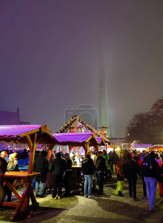 Foto de BERLÍN, ALEMANIA - 1 DE DICIEMBRE DE 2023: Gente disfrutando de la comida tradicional y la cerveza en el Mercado de Navidad cerca de Alexanderplatz (Weihnachtsmarkt am Roten Rathaus) - Imagen libre de derechos