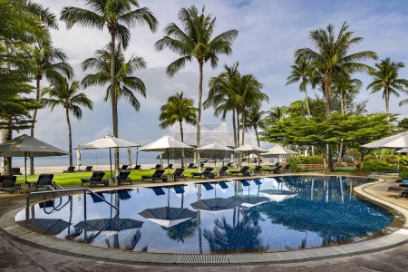 Foto de Malasia, Langkawi, noviembre de 2022: Piscina entre un hermoso jardín con palmeras altas en el territorio del hotel Casa del Mar Langkawi, Malasia - Imagen libre de derechos
