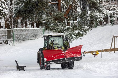 Téléchargez les photos : Déneigement. Le tracteur ouvre la voie après de fortes chutes de neige à Riga, en Lettonie. Nettoyage des routes dans la ville de la neige en hiver. - en image libre de droit