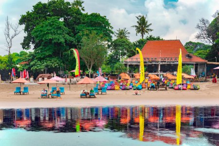 Téléchargez les photos : INDONÉSIE, BALI, SEMINYAK, NOVEMBRE 2022 : Les gens se reposent sur des chaises longues colorées sur la plage de Seminyak, Bali, Indonésie. Concept de voyage. - en image libre de droit