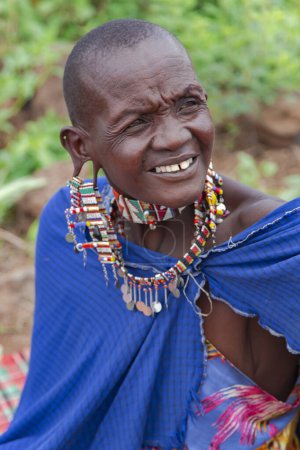 Photo for AFRICA, KENYA, MAY, 2016 - Portrait of a woman of the Maasai Mara tribe with traditional dress and braided beaded jewelry in Kenya, Africa - Royalty Free Image
