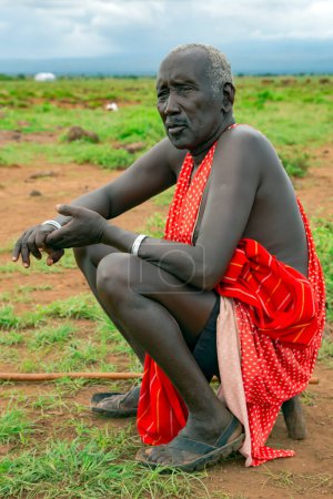 Photo for AFRICA, KENYA, MAY, 2016 - Portrait of old african men sitting on a green meadow in Masai tribe village. The Maasai are a Nilotic ethnic group living in southern Kenya and northern Tanzania. - Royalty Free Image