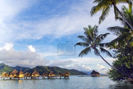 Photo for Overwater bungalows stretching and a wooden bridge out across the lagoon in Bora Bora island, Tahiti. Romantic honeymoon destination. - Royalty Free Image