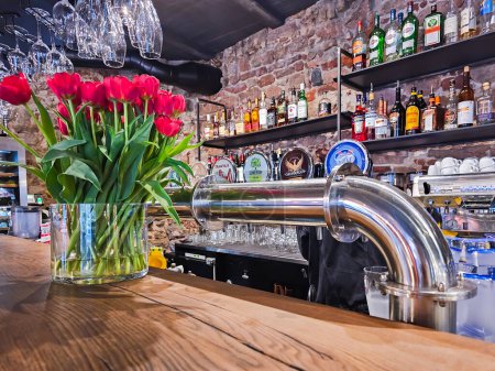 Photo for LATVIA, RIGA, 23, APRIL, 2023: Bar counter with alcoholic drinks and metal of tap for pouring beer in bar interior in Riga Old Town, Latvia - Royalty Free Image
