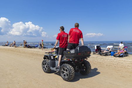 Photo for LATVIA, JURMALA, 07, JULY, 2023: Lifeguards on ATVs driving along the coastline of the Baltic Sea in especially dangerous weather at Majori, Jurmala. Latvia - Royalty Free Image