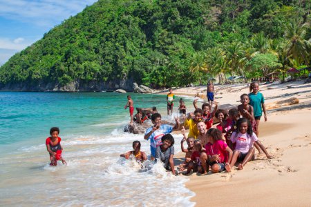 Téléchargez les photos : PAPOUASIE NOUVELLE GUINEE, JAYAPURA, 15 AOÛT 2019 - Des enfants drôles indonésiens sont photographiés avec des touristes sur la plage de la base de Pantai à Sentani, Jayapura, Nouvelle-Guinée. - en image libre de droit