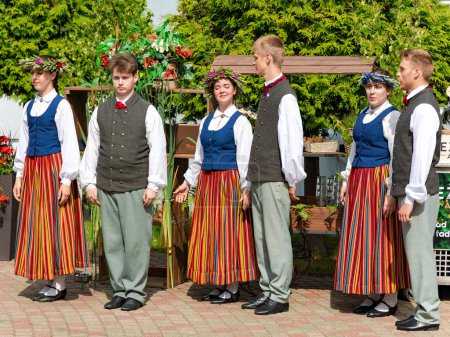 Foto de LATVIA, JURMALA, 23, JUNIO, 2023: Un conjunto en trajes nacionales letones está bailando en las vacaciones del Solsticio de Verano en Jurmala, Letonia. Concepto auténtico. - Imagen libre de derechos