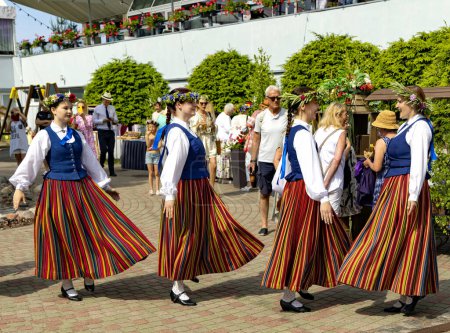Foto de LATVIA, JURMALA, 23, JUNIO, 2023: Un conjunto en trajes nacionales letones está bailando en las vacaciones del Solsticio de Verano en Jurmala, Letonia. Concepto auténtico. - Imagen libre de derechos