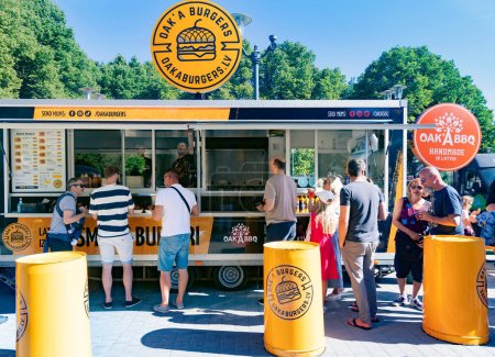 Téléchargez les photos : LETTONIE, RIGA, 15 AOÛT 2023 : Des gens attendent des hamburgers au food truck du Riga Burger Festival au parc de l'Esplanade à Riga. Lettonie. - en image libre de droit