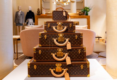 Foto de ITALIA, MILÁN, 25, AGOSTO, 2023: Las modernas maletas y bolsos de Louis Vuitton están en el centro del área de ventas de la boutique en Milán, Italia - Imagen libre de derechos