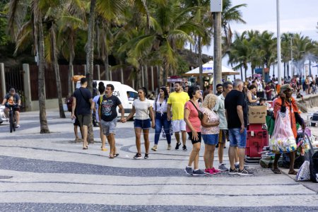 Foto de BRASIL, RIO DE JANEIRO, 23 de noviembre de 2023: Turistas y turistas en el paseo marítimo de la playa de Ipanema en Río de Janeiro. Brasil - Imagen libre de derechos