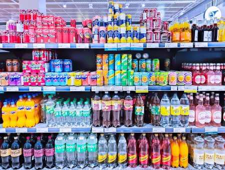 Foto de LATVIA, RIGA, 02, MAYO, 2024: Bebidas gaseosas en estantes para la venta en la sección de alimentos grandes en el supermercado Riga. Letonia. El surtido incluye Coca Cola, Fanta, Sprite y otras bebidas. - Imagen libre de derechos