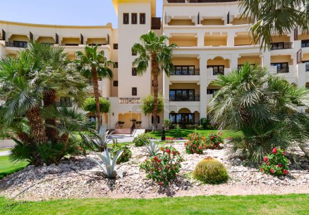 Schöne Landschaft mit Palmen, Kakteen und blühenden Sträuchern auf dem Gelände eines modernen Hotels in Hurghada, Ägypten.