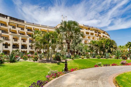 Hermoso paisaje con palmeras, cactus y arbustos florecientes en el territorio de un hotel moderno en Hurghada, Egipto.