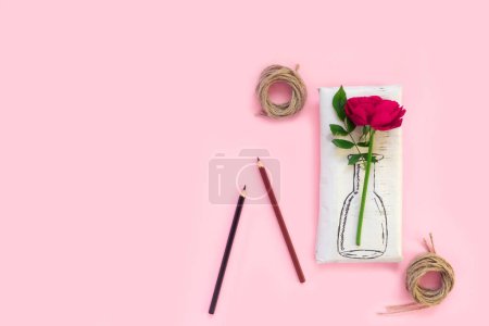 Foto de Set of wrapping paper and flowers for handmade on pink background. Homemade craft box gifts with painted vase, bouquet of red roses - Imagen libre de derechos