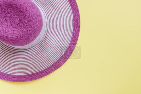 Foto de Sombrero de paja rosa de moda sobre fondo de papel amarillo - Imagen libre de derechos