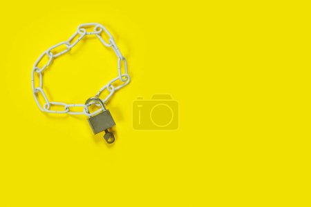 Photo for The padlock and chains on yellow background. Flat lay, top view with copy space for text. Banner. - Royalty Free Image