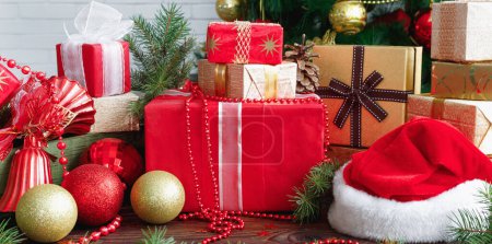 Foto de Cajas de regalo con cuentas, juguetes y sombrero de Papá Noel en la mesa de madera vintage en Navidad - Imagen libre de derechos