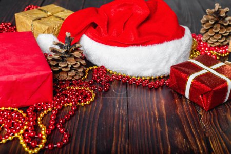 Téléchargez les photos : Coffrets cadeaux avec perles, jouets et chapeau de Père Noël sur table en bois vintage à Noël - en image libre de droit