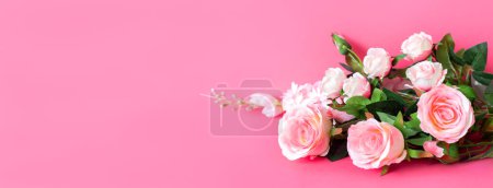 Téléchargez les photos : Bouquet de délicates roses blanches artificielles sur fond rose. Fleurs décoratives à l'intérieur de la maison. - en image libre de droit