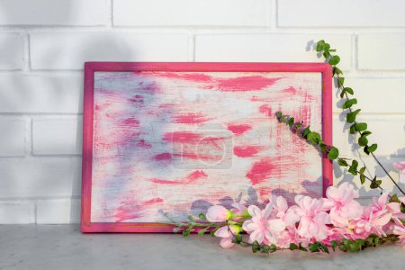 Foto de Marco vintage de madera y un ramo de flores rosadas sobre un fondo de pared de ladrillo. Interior del hogar - Imagen libre de derechos