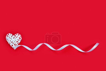 Téléchargez les photos : Beau coeur sur fond de papier rouge pour la Saint Valentin avec ruban. Carte de vœux créative - en image libre de droit