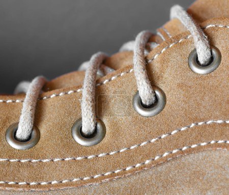 Photo for Part of a brown leather boot with a metal rivet. - Royalty Free Image