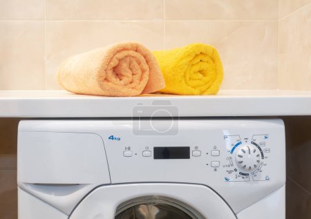 Téléchargez les photos : Pair clean rolled towels on washing machine . - en image libre de droit