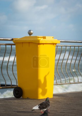 Photo for Yellow garbage container by the sea . - Royalty Free Image