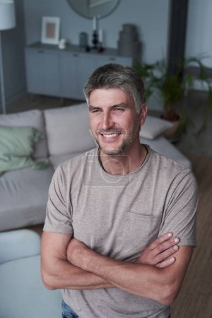 Téléchargez les photos : Portrait homme souriant attrayant relaxant à la maison - en image libre de droit