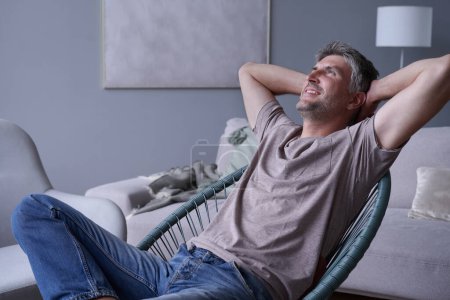 Téléchargez les photos : Portrait homme souriant attrayant relaxant à la maison - en image libre de droit