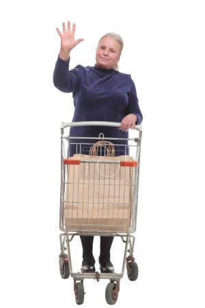 Photo for Full length shot of a senior lady waving and pushing an empty shopping cart isolated on white background - Royalty Free Image