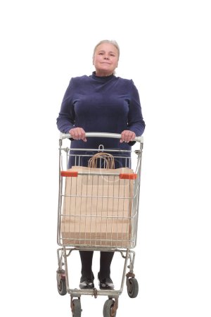 Téléchargez les photos : Plan complet d'une femme âgée poussant un chariot isolé sur fond blanc souriant à la caméra - en image libre de droit