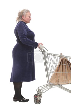 Foto de Vista lateral de la mujer de pie con carro de la compra con bolsas de papel aisladas sobre fondo blanco - Imagen libre de derechos
