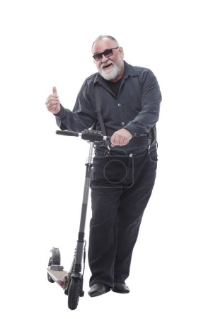 Foto de En pleno crecimiento. anciano de pie en scooter eléctrico. aislado sobre un fondo blanco - Imagen libre de derechos