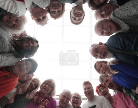 Foto de Gente feliz mirando hacia abajo a la cámara permanecer en sircle - Imagen libre de derechos
