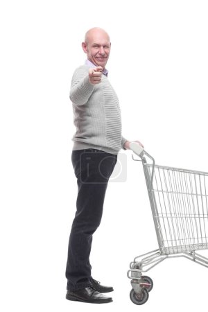 Photo for In full growth. a happy man with a shopping cart. isolated on a white background. - Royalty Free Image