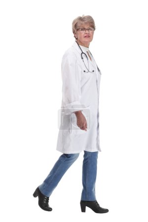 Téléchargez les photos : Médecin femme marchant vers la caméra souriant isolé sur un fond blanc - en image libre de droit