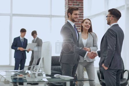 Photo for Partners concluding deal and shaking hands in the presence of team members - Royalty Free Image