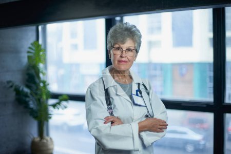 Photo for Friendly mature female doctor at hospital smiling - Royalty Free Image