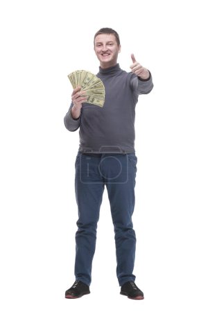 Photo for In full growth. casual young man with dollar bills. isolated on a white background. - Royalty Free Image