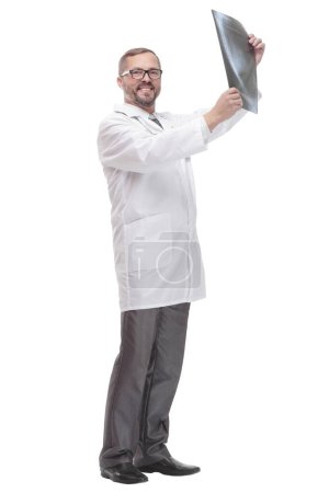 in full growth. competent doctor looking at an x-ray . isolated on a white background.