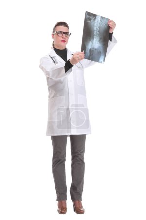 Téléchargez les photos : Vue de face d'une femme médecin portant un stéthoscope et des lunettes regardant une radiographie. Concept d'aide médicale - en image libre de droit