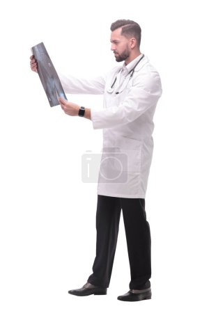 Photo for In full growth. medical doctor looking closely at the x-ray . isolated on white background - Royalty Free Image