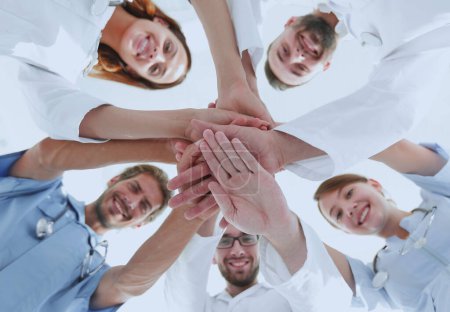 Téléchargez les photos : Une équipe de médecins du centre médical s'est serrée les mains ensemble. Le concept d'unité - en image libre de droit