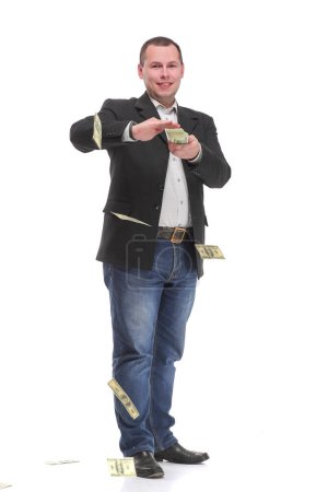 Téléchargez les photos : Beau jeune homme en tenue de cérémonie jetant de l'argent et regardant la caméra. Consept de riches et réussis. - en image libre de droit
