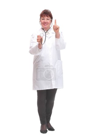 Mature woman doctor with stethoscope in ears and checking listening heart pulse pose, studio white background copy space