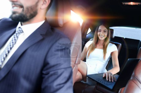 Téléchargez les photos : Femme entrepreneur travaillant pendant un voyage au bureau dans une voiture de luxe. - en image libre de droit