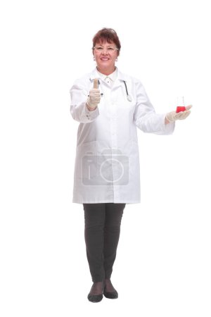 Téléchargez les photos : Vue de face du scientifique femelle avec un bécher de liquide rouge sur la paume regardant la caméra - en image libre de droit