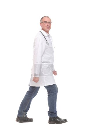 Photo for Middle age doctor with stethoscope walking on white background, side view - Royalty Free Image